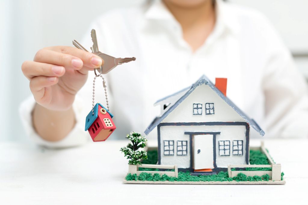 real-estate-agent-with-house-model-keys-scaled